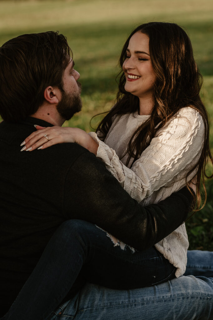 Couple looking at each other sitting under a tree