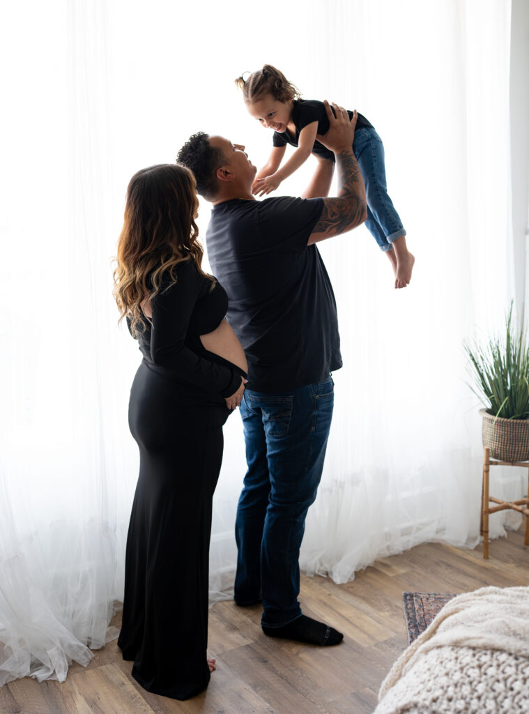 Family posing in front of studio window