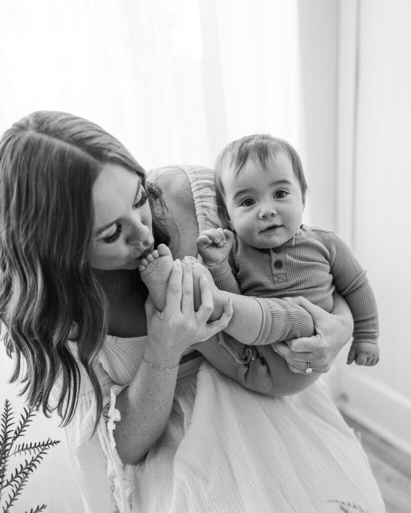 mother and infant son posing for mothers day photos in a studio
