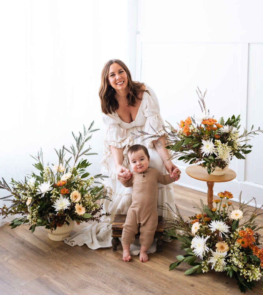 mother and infant son posing for photos in a studio with real florals for mothers day minis just west of Indianapolis